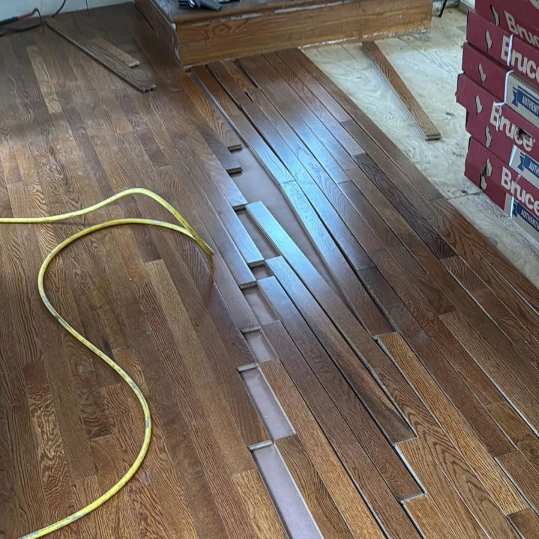 Hardwood flooring installation in progress with new planks