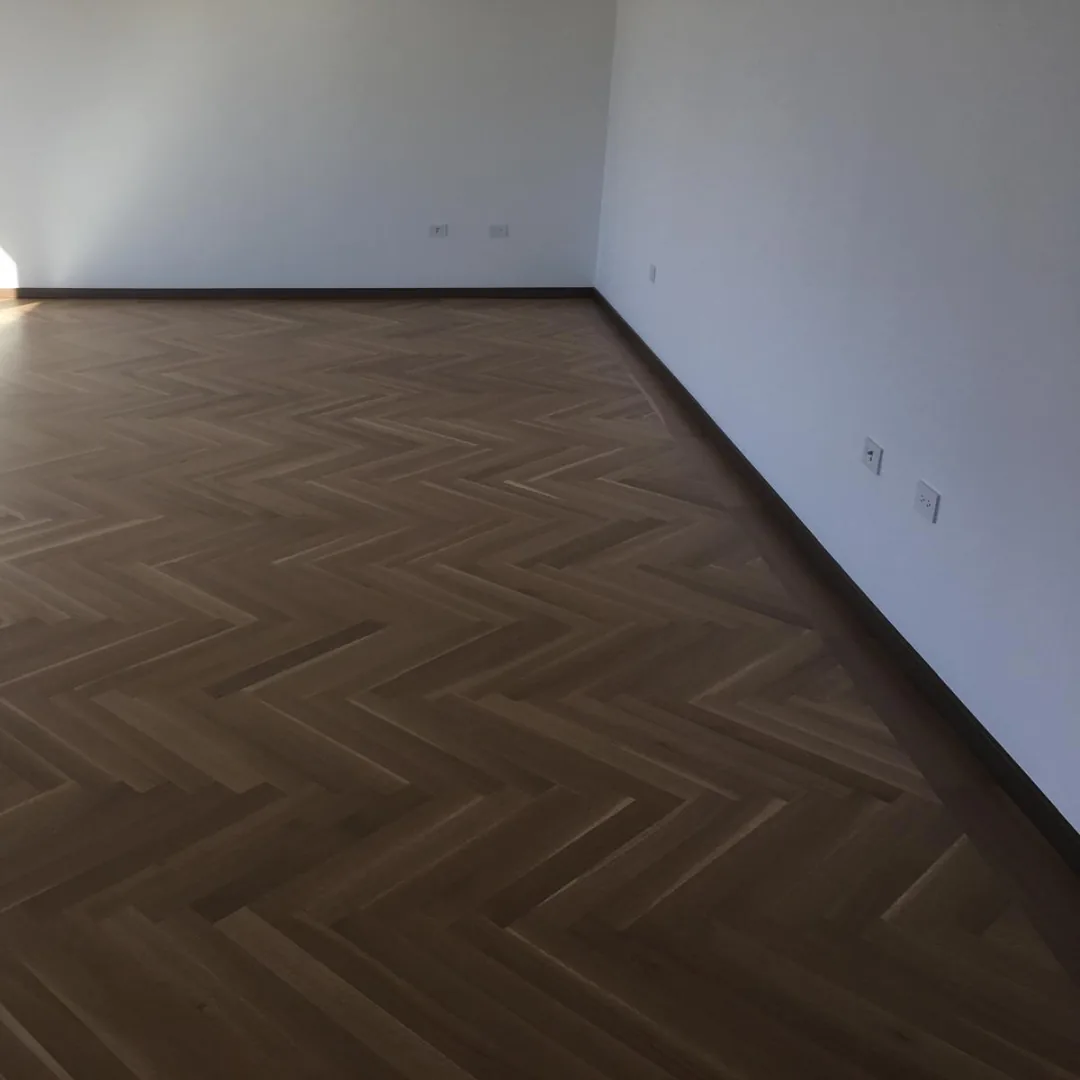 Dark brown herringbone hardwood flooring in an empty room