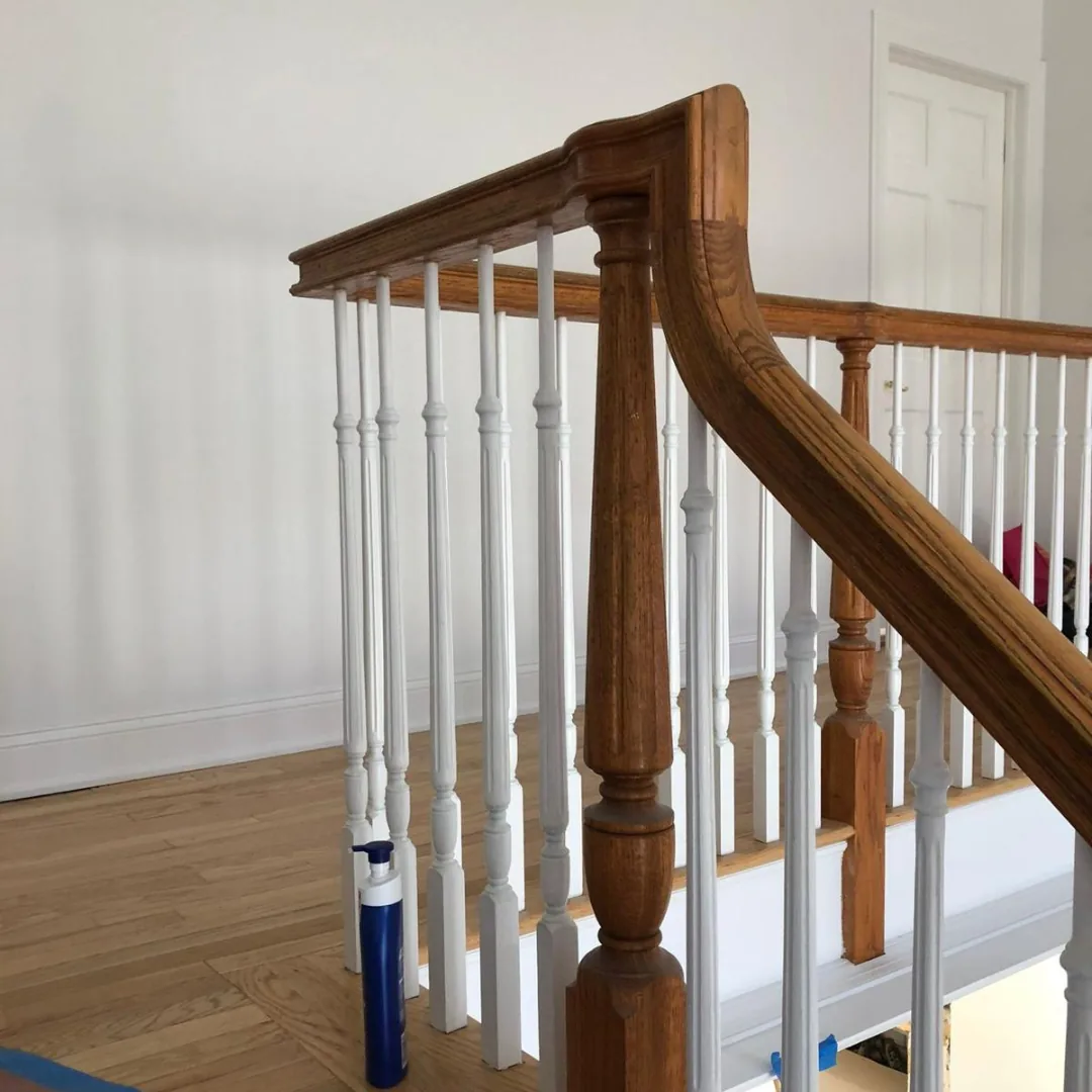New oak handrail and white balusters during stair railing installation