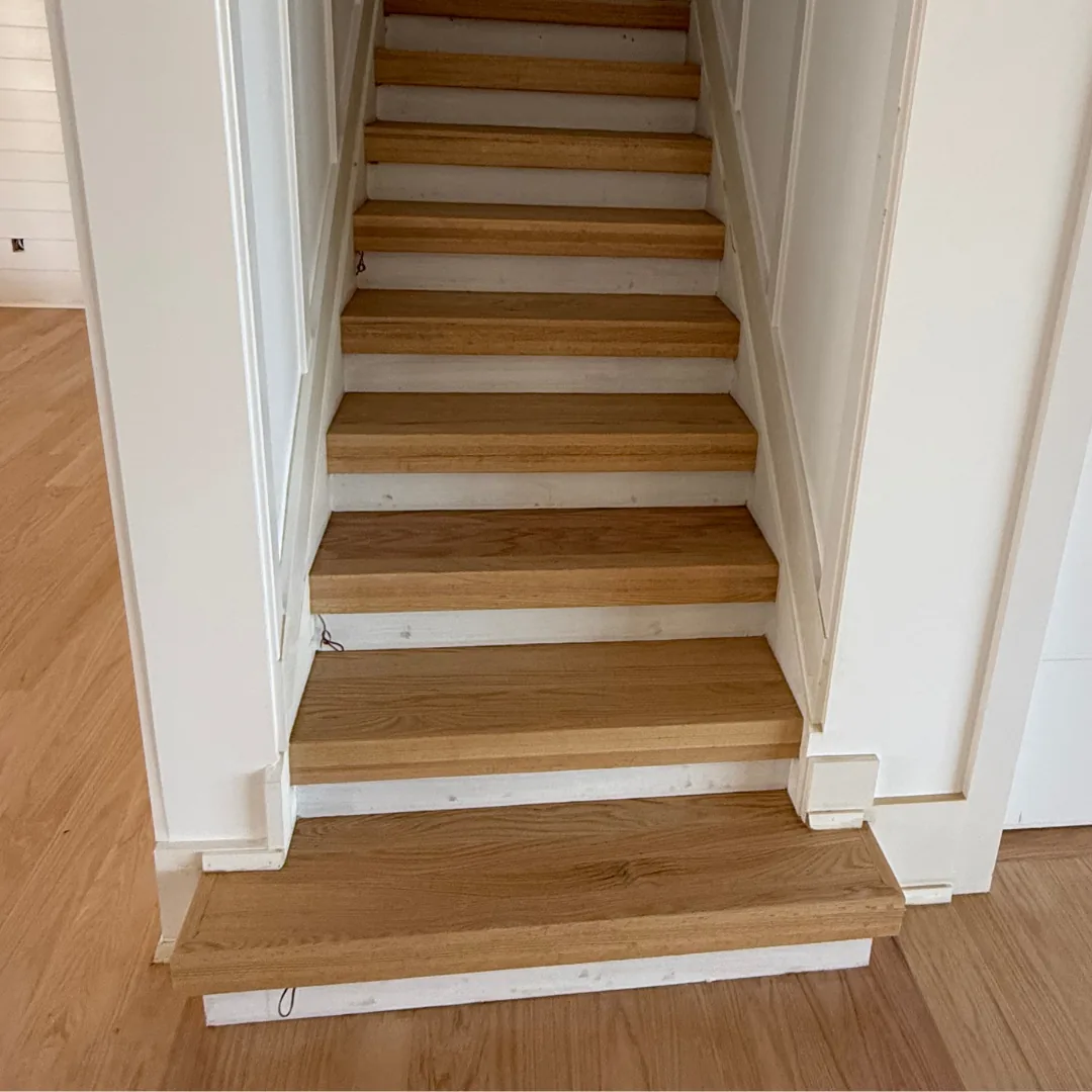 Hardwood stair treads and risers with white trim.